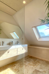 An Italian bathroom with travertine tiles and view over valley and hills.