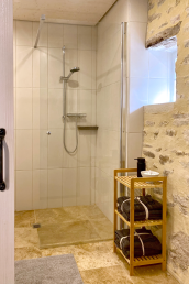 An en-suite Italian bathroom with travertine tiles, wheelchair accessible.