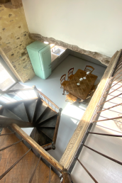 A Helicopter view on the spiral staircase in the kitchen with large Smeg fridge and dining table.