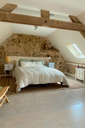 A spacious bedroom with a double bed, 1.80mx2.10m, with possibility to covert into two single beds, a design chair and refurbished brocante furniture.